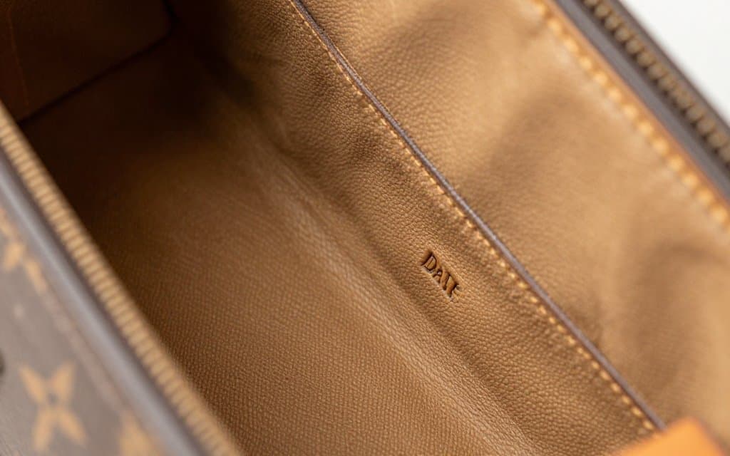 Macro view of a Louis Vuitton bag interior showing the date code stamp, key to knowing how to tell if a Louis Vuitton bag is real