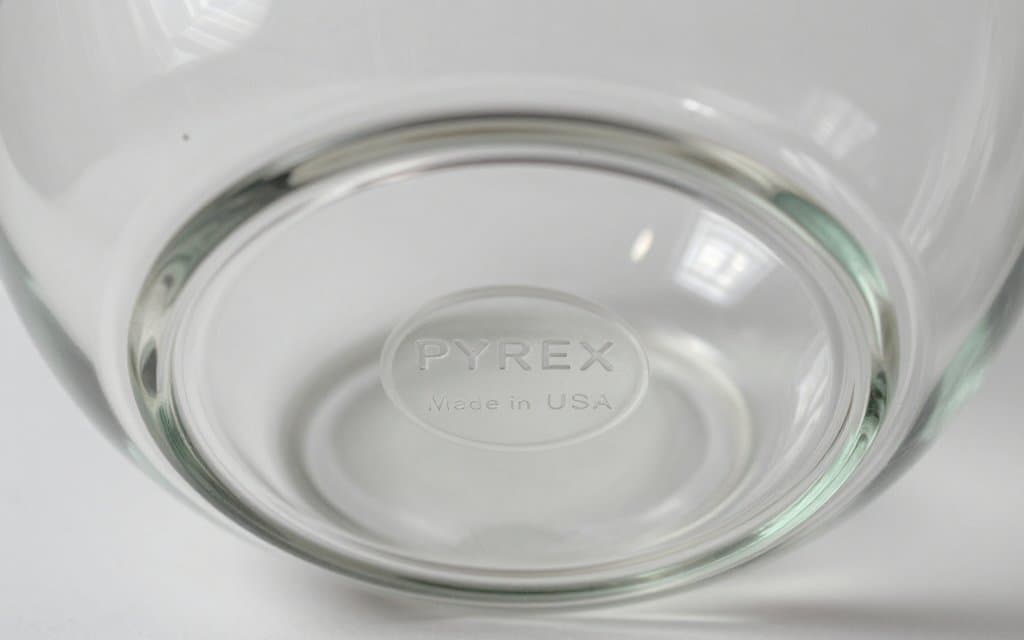 Macro of a vintage Pyrex backstamp showing the capital PYREX logo and model number used to date patterns.