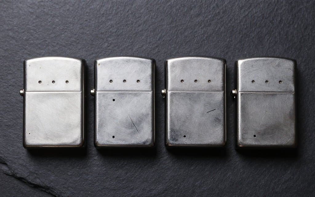 Four vintage Zippo bases compared, showing dots, lines and slashes date codes