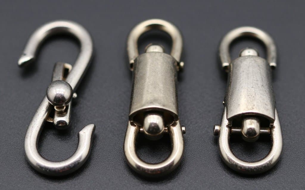 Comparison of C clasp, trombone, and safety catch on the back of a vintage costume brooch.