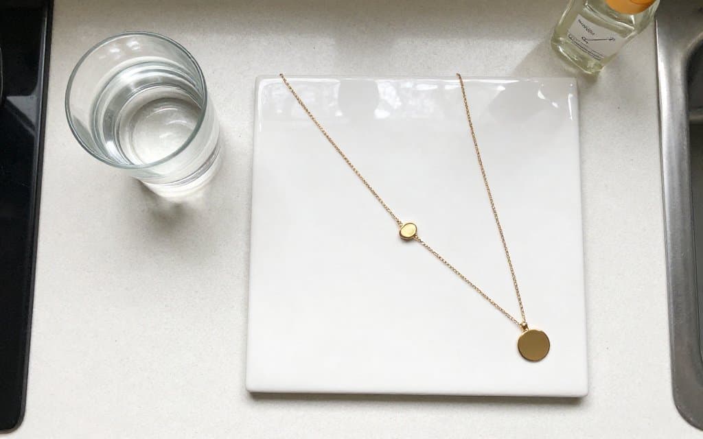 Top-down flat lay of simple tools used to test gold at home for real gold