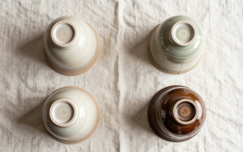 Top down view of roseville pottery marks across four vase bases