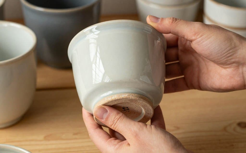 Hands checking mccoy pottery marks on a vintage planter base