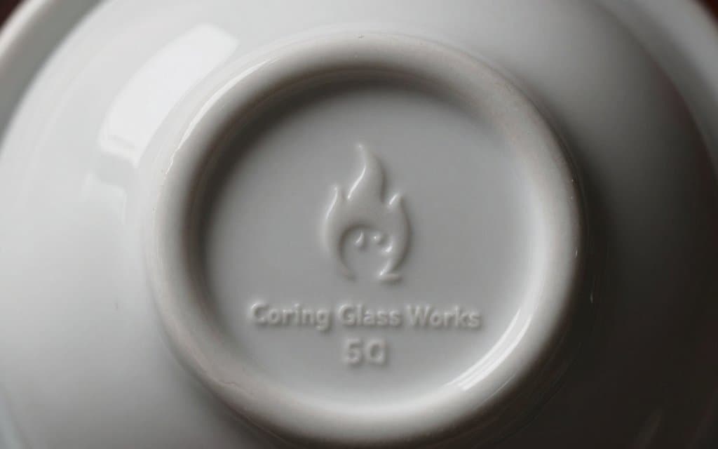 Macro of a vintage Corningware backstamp showing the flame logo and model number