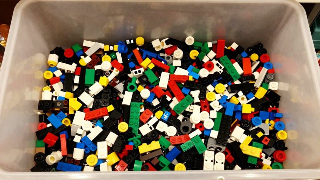 Overhead photo of a thrift store bin full of loose Lego bricks holding valuable Lego minifigures