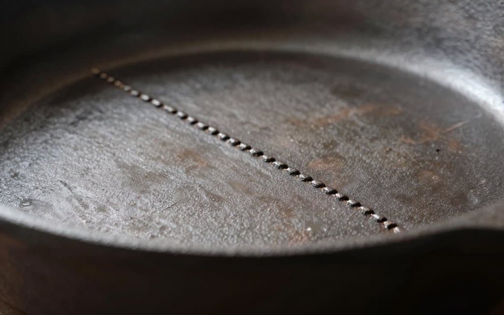 Macro close up of the raised seam on the base of a gate mark cast iron skillet