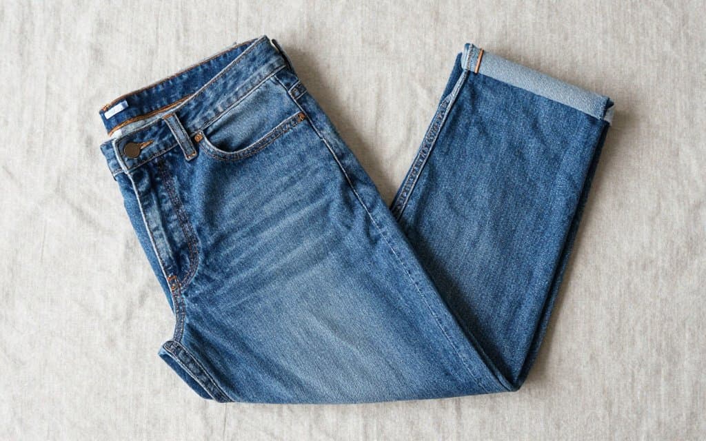Top down flat lay of folded vintage Levis 501 jeans showing the button fly and rivets