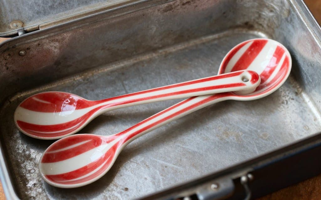 Vintage red and white fishing lures and Dardevle spoons in an old tackle box