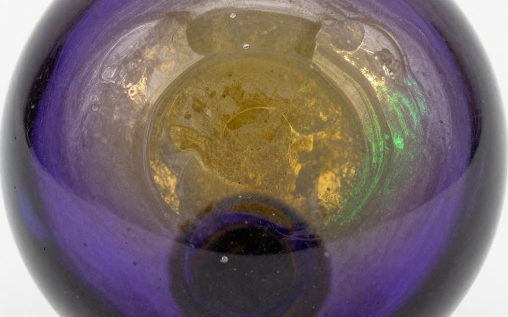 Macro view of the rainbow sheen sprayed onto an old piece of pressed glass