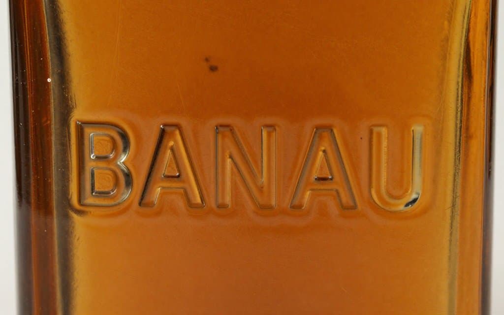 Macro of embossing on an amber antique glass liquor bottle that raises its value