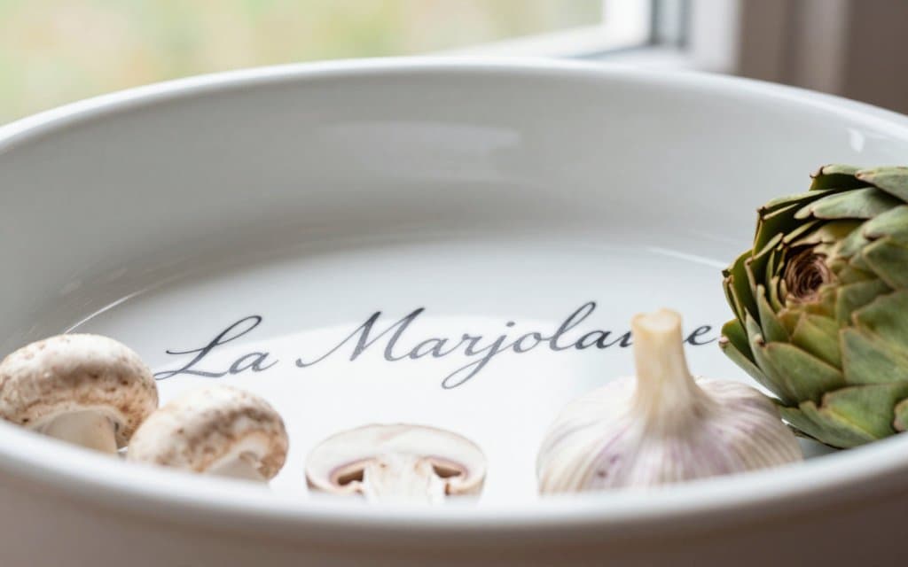 Macro of La Marjolaine CorningWare script under the vintage vegetable pattern