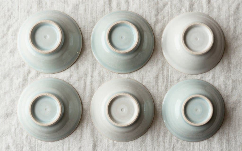 Top down view of several McCoy pottery marks on upturned vintage planters and vases