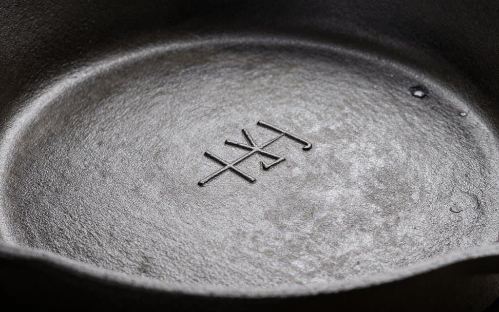 Macro view of the maker marks on the bottom of a vintage iron skillet