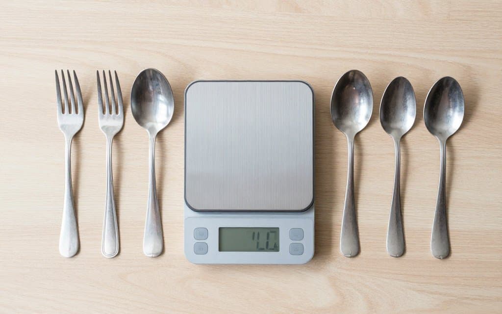 Top down sterling silverware pieces on a scale to weigh melt value