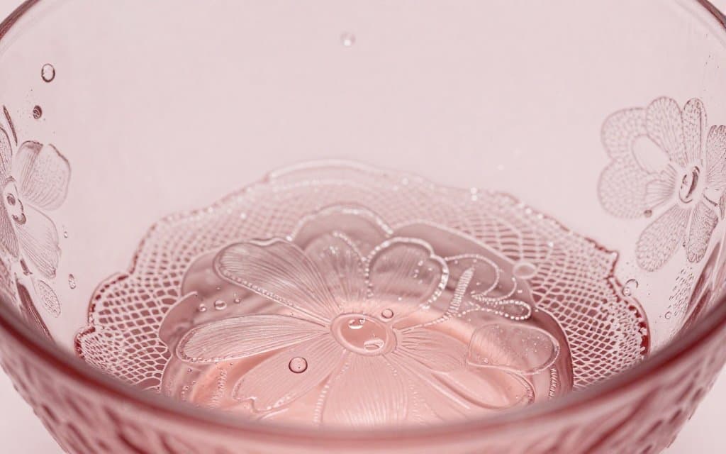 Macro close-up of a pressed pattern on pink depression glass showing mold detail