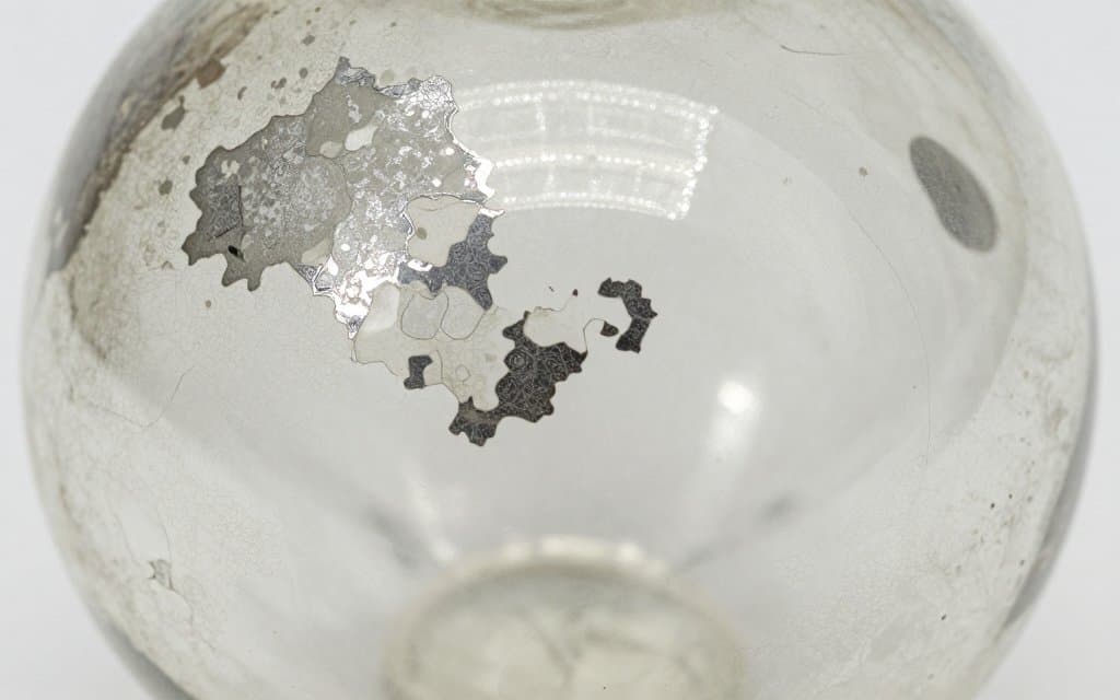 Close up of paint loss and wear on an antique glass Christmas ornament
