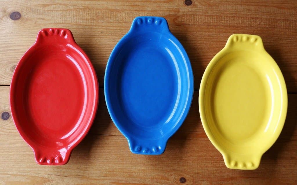 Upturned vintage Fiestaware plates on a table showing the marks and glazed bases used to date radioactive Fiestaware