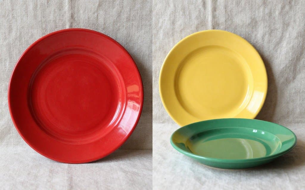 Red, yellow and medium green Fiesta plates side by side comparing radioactive Fiestaware with common colors