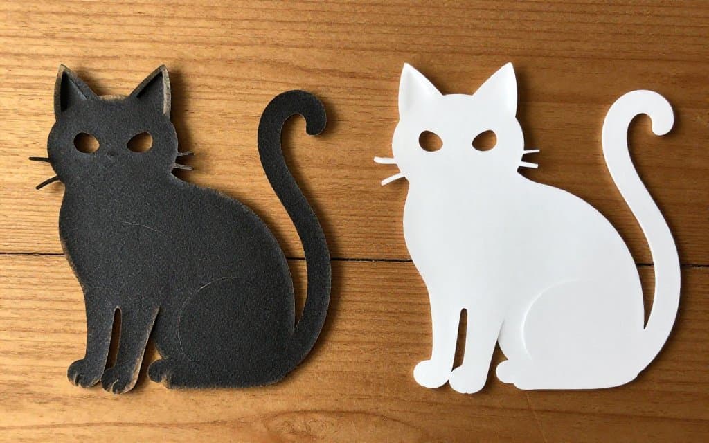 Original embossed Beistle Halloween die cut beside a glossy reissue, showing the difference in card stock